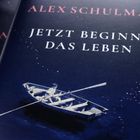 "Jetzt beginnt das Leben" steht groß. Ein Junge rudert in einem Boot allein auf dunklem Wasser.