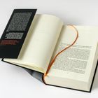 Buch aufgeschlagen mit einem schwarzen Einbandtext, orangefarbenes Lesebändchen, geöffnete Seiten, Kapitel beginnt bei "1".