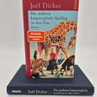 "Joël Dicker, Der äußerst katastrophale Ausflug in den Zoo. Illustration mit Giraffe, Tiger und Frau auf Buchcover."