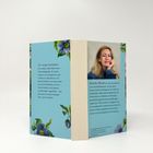 Text links: "Die ewige Schönheit der weißen Gipfel hatte etwas Überwältigendes..."
Text rechts: "Amelia Martin ist das Pseudonym einer Bestsellerautorin..."
Hintergrund hellblau mit Blumenmotiven. Rechts Foto einer lächelnden Frau.