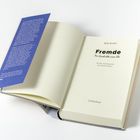 Ein aufgeschlagenes Buch mit dem Titel "Fremde: Die Geschichte einer Ehe" von Belle Burden.
