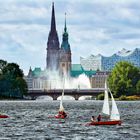 Text: Fehlanzeige. Mehrere Segelboote auf einem Fluss, historische Gebäude im Hintergrund. Wolkiger Himmel.