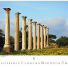 Famagusta, römische Ruinen von Salamis. Unten: Zahlen 1-30 für den Monat. Säulen vor bewölktem Himmel und gelben Blumen.