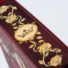Ein Buchrücken in dunklem Rot mit goldenen Rosen und Krone als Verzierung.