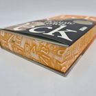 Der Buchrücken zeigt Buchstaben auf orangefarbenem Hintergrund, der Titel ist weiß auf schwarzem Cover.