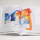 Texte: "AUSSTELLUNGSANSICHTEN", "EXHIBITION VIEWS". Gezeigt wird ein Katalog mit farbenfrohen Installationen aus Stoffen und Leinwänden.