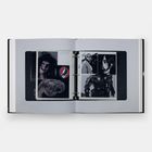 Offenes Buch mit Fotos: Rockband-Logo, maskierte Person, Roboter, Frau mit langen Haaren, und Tierkopf.