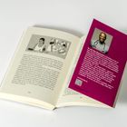 Ein aufgeschlagenes Buch mit einer Einlage. Links Fließtext mit einer Illustration von Figuren und medizinischem Gerät. Rechts eine Einlage mit einem Foto eines lächelnden Mannes sowie einem text über "Dr. med. Nana Bitmano-Boie" und einer URL: www.herzandc.de. 