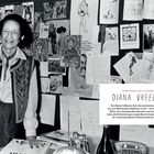 MODEIKONE UND VISIONÄRIN DIANA VREELAND. Eine ältere Frau steht lächelnd vor einer Pinnwand voller Bilder und Notizen.
