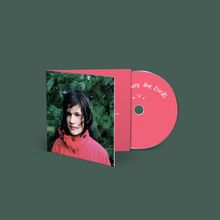 "Here the birds" steht auf einer rosa CD. Ein Foto zeigt eine Person in rotem Mantel vor grünen Zweigen.