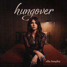 „hungover“ und „ella langley“ in stilisierter Schrift. Frau mit langen Haaren und türkisfarbenem Schmuck sitzt auf einem Bett.