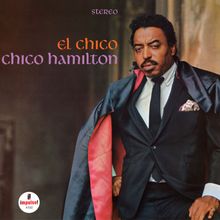 "el chico chico hamilton" in stilvollem Schriftzug. Ein Mann im Anzug mit Umhang, wirkt selbstbewusst. Logo unten links.