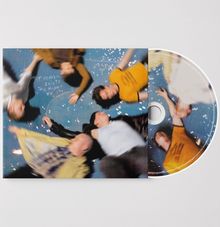 Text: "IF HEAVEN EXISTS, THIS MIGHT BE IT." Fünf Personen liegen auf blauem Boden, der mit weißen Punkten bedeckt ist.