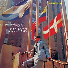 Text: „the stylings of SILVER“, „BLUE NOTE 1562“. Ein Mann in Anzug lehnt an einem Geländer, hinter ihm wehen Flaggen.