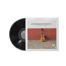 Eine Liste von Songtiteln. Rechts ein Albumcover mit einer Gitarre an einer roten Wand. Links eine schwarze Schallplatte.