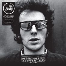 Texte: „Dark Horse Records“, „Joe Strummer 003: The 101'ers Years 1974–1976“. Schwarz-Weiß-Porträt eines Mannes mit Sonnenbrille.