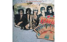 "TRAVELING WILBURYS". Ein altes Poster zeigt fünf Männer mit Sonnenbrillen und ein buntes Logo.