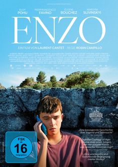 ENZO. FSK ab 16 freigegeben. Junge in lila T-Shirt telefoniert vor Fels, blauer Himmel im Hintergrund.
