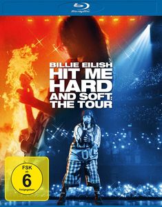 "BILLIE EILISH HIT ME HARD AND SOFT: THE TOUR" in großen Buchstaben, "VORAB-COVER" und "FSK ab 6 freigegeben". Künstler auf Bühne.