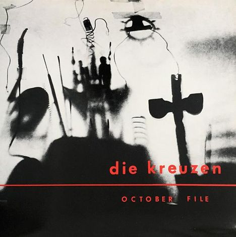 Text: "die kreuzen", "OCTOBER FILE". Schwarze, abstrakte Silhouetten vor grauem Hintergrund.