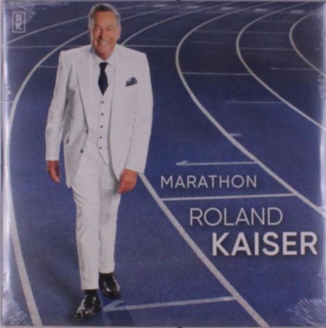 "Marathon Roland Kaiser" Text über einer blauen Laufbahn. Ein Mann im weißen Anzug geht lächelnd.
