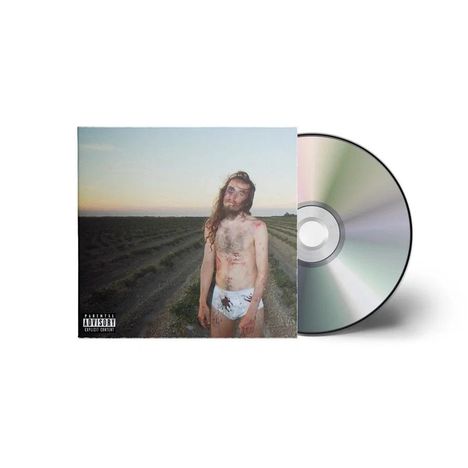 Ein Mann mit blauen Flecken steht in Unterwäsche auf einem Feld bei Sonnenuntergang, daneben eine CD.