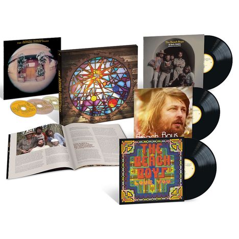 "The Beach Boys" und "The Beach Boys Love You" auf Albumhüllen, Buch offen mit Text, 3 CDs, 3 Schallplatten, farbenfrohes Design.