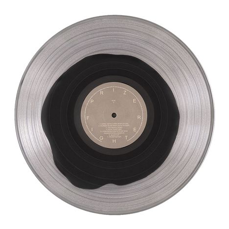 Eine Schallplatte mit grauer Mitte, schwarzer Vinylfläche. Texte: "PRIZE FIGHT", "SIDE A" und Trackliste.