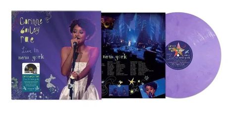 "Corinne Bailey Rae Live in New York." Sängerin mit Mikrofon, violetter Hintergrund, Aufkleber mit Schallplatte.