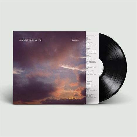 „CLAP YOUR HANDS SAY YEAH BURNED“ auf einem Albumcover mit einem Himmel bei Sonnenuntergang und einer Schallplatte.