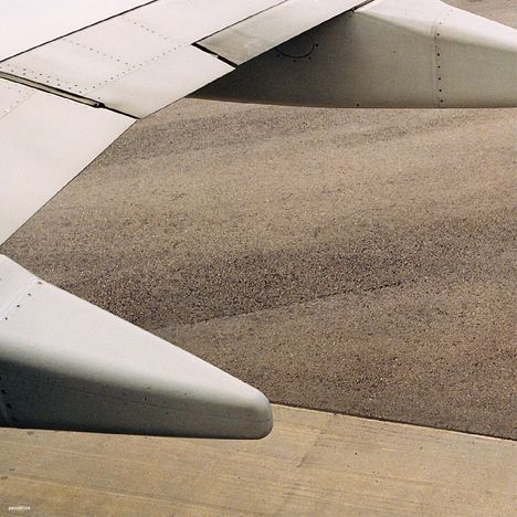 Der Text "pennines" befindet sich unten links. Man sieht den Flügel eines Flugzeugs und eine asphaltierte Landbahn.