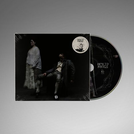 "Hold Fangs" und ein kunstvolles Logo. Eine düstere Szene mit zwei stehenden Figuren auf einer CD-Hülle.