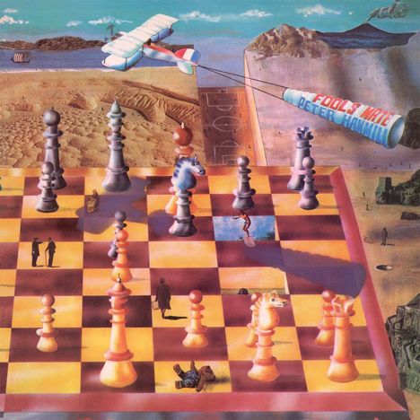 "FOOLS MATE PETER HAMMILL" steht an einem Flugzeugbanner. Eine surreale Landschaft mit riesigem Schachbrett und Figuren.