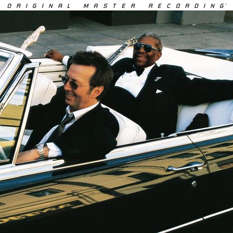 "ORIGINAL MASTER RECORDING" steht am oberen Rand. Zwei Männer in Anzügen sitzen lächelnd in einem Cabrio.