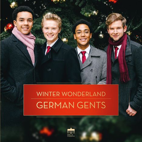 "WINTER WONDERLAND GERMAN GENTS" vor einem weihnachtlich geschmückten Baum; vier lächelnde Männer in Mänteln und Schals.