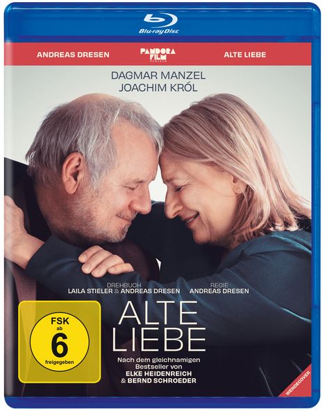 Zwei ältere Menschen, ein Mann und eine Frau, berühren sanft ihre Stirnen und lächeln.