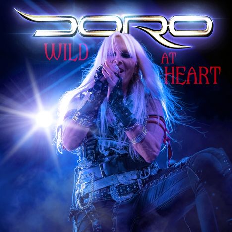 "Wild at Heart" in roten Buchstaben, Frau mit Mikrofon, Rock-Mode, leuchtende Bühne.