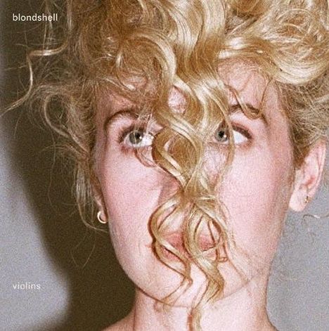 Text: "blondshell" und "violins". Eine Person mit blonden, lockigen Haaren verdeckt leicht ihr Gesicht.