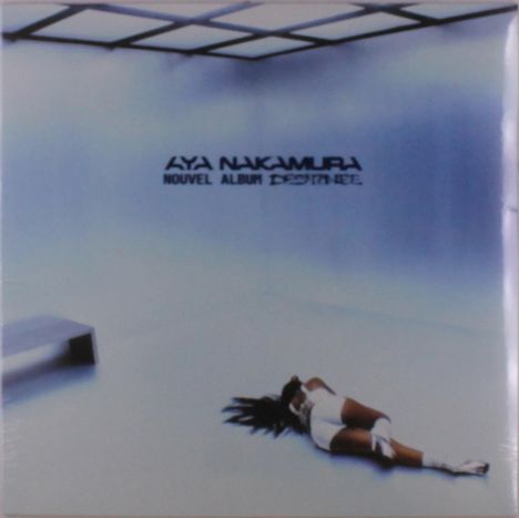Text: "Aya Nakamura Nouvel Album." Frau in weißem Outfit liegt in kargem, bläulich beleuchtetem Raum.