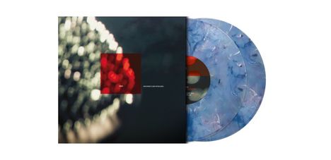 "Movements and Interludes" steht weiß auf dunklem Hintergrund. Zwei schimmernde Schallplatten in Blau sind teilweise sichtbar.
