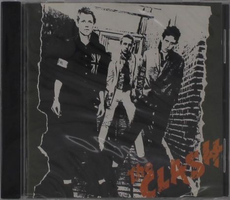 "The Clash" in orange Schrift. Drei Männer in Schwarz-Weiß stehen in einer Gasse. Punk-Ästhetik, abgetragen und roh.