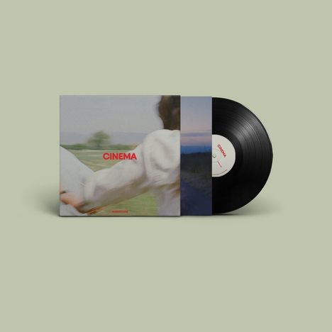 Text: "CINEMA" in Rot auf einem Albumcover. Verschwommenes Bild einer Person in freier Natur. Schallplatte teilweise sichtbar.