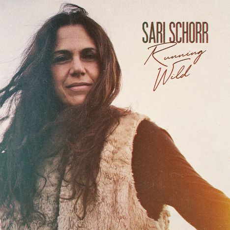 "SARI SCHORR Running Wild" in eleganter Schrift. Eine Frau mit langen Haaren und einer Fellweste blickt ruhig in die Kamera.