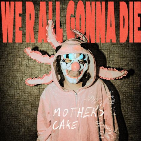 „WE'RE ALL GONNA DIE“ und „MOTHERS CAKE“. Eine Person trägt ein Kostüm mit Clownmaske und Hasenohren.
