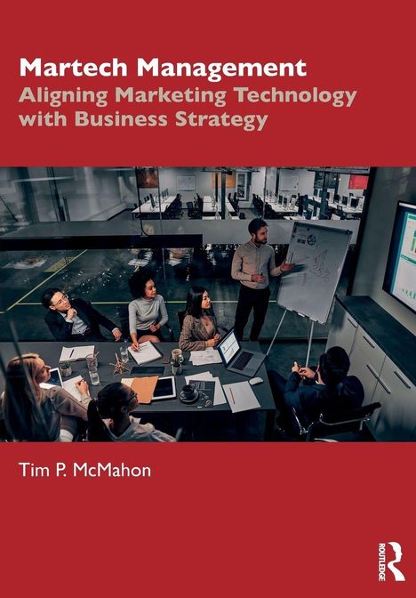 "Martech Management" oben, "Tim P. McMahon" unten. Menschen in Meetingraum um Tisch, Präsentation an Flipchart.