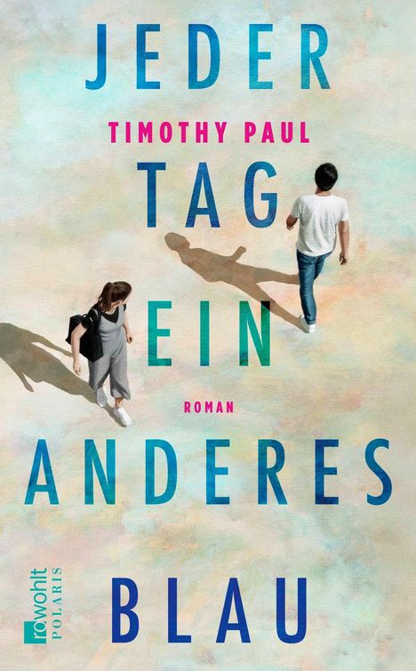 "Jeder Tag ein anderes Blau" von Timothy Paul. Zwei Personen gehen auf sandigem Hintergrund, ihre Schatten sind sichtbar.