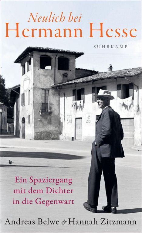 "Neulich bei Hermann Hesse", ein Mann in Anzug und Hut in einem sonnigen Dorfplatz.