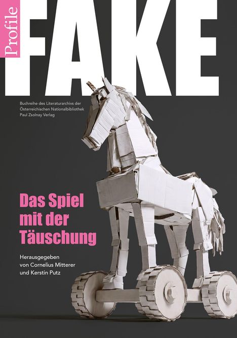 "FAKE" in großen, weißen Buchstaben. Darunter: "Das Spiel mit der Täuschung". Papp-Trojanisches Pferd auf Rädern.