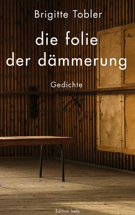 Text: "Brigitte Tobler, die folie der dämmerung, Gedichte, Edition Isele." Ein leerer Holzraum mit einem Tisch.