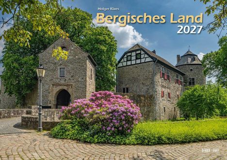 "Holger Klaes Bergisches Land 2027" steht zentral. Historische Gebäude, blühender Rhododendron und Kopfsteinpflaster.